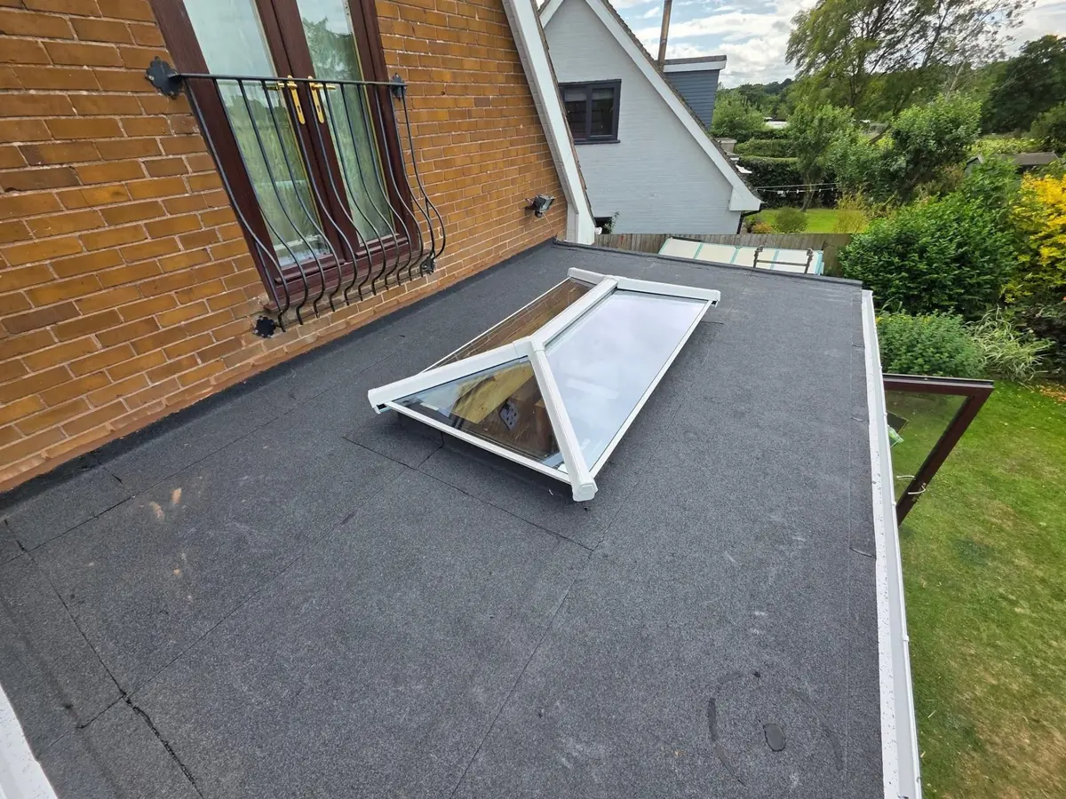 Newly installed torch-on felt flat roof with white uPVC roof lantern, close-up