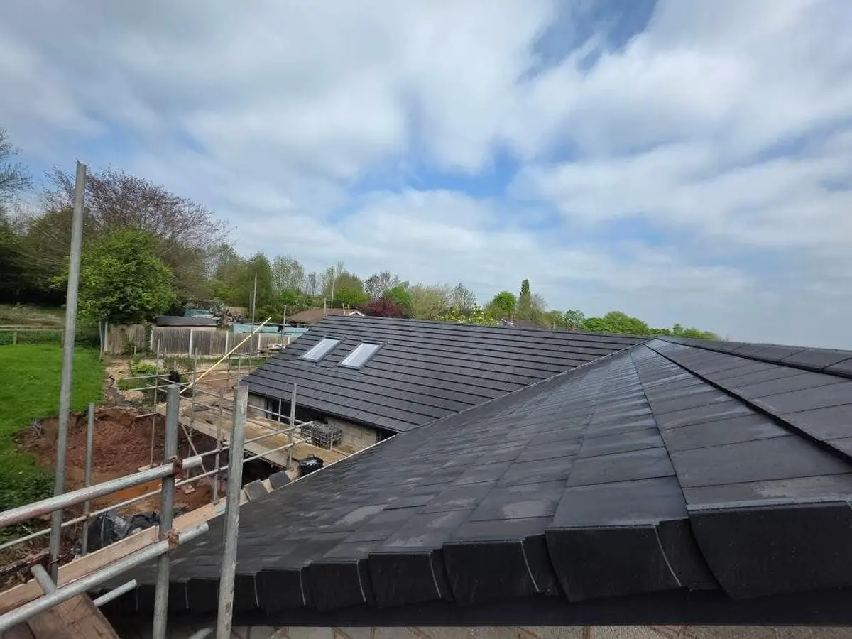 Wide-angle view of a new build roof with multiple pitches, Velux windows and dry hip system