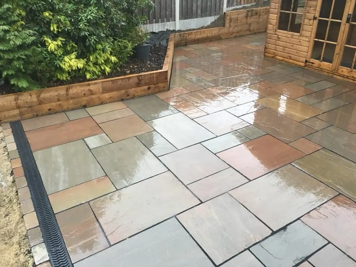 ACO drainage channel installed along the edge of an Indian sandstone patio