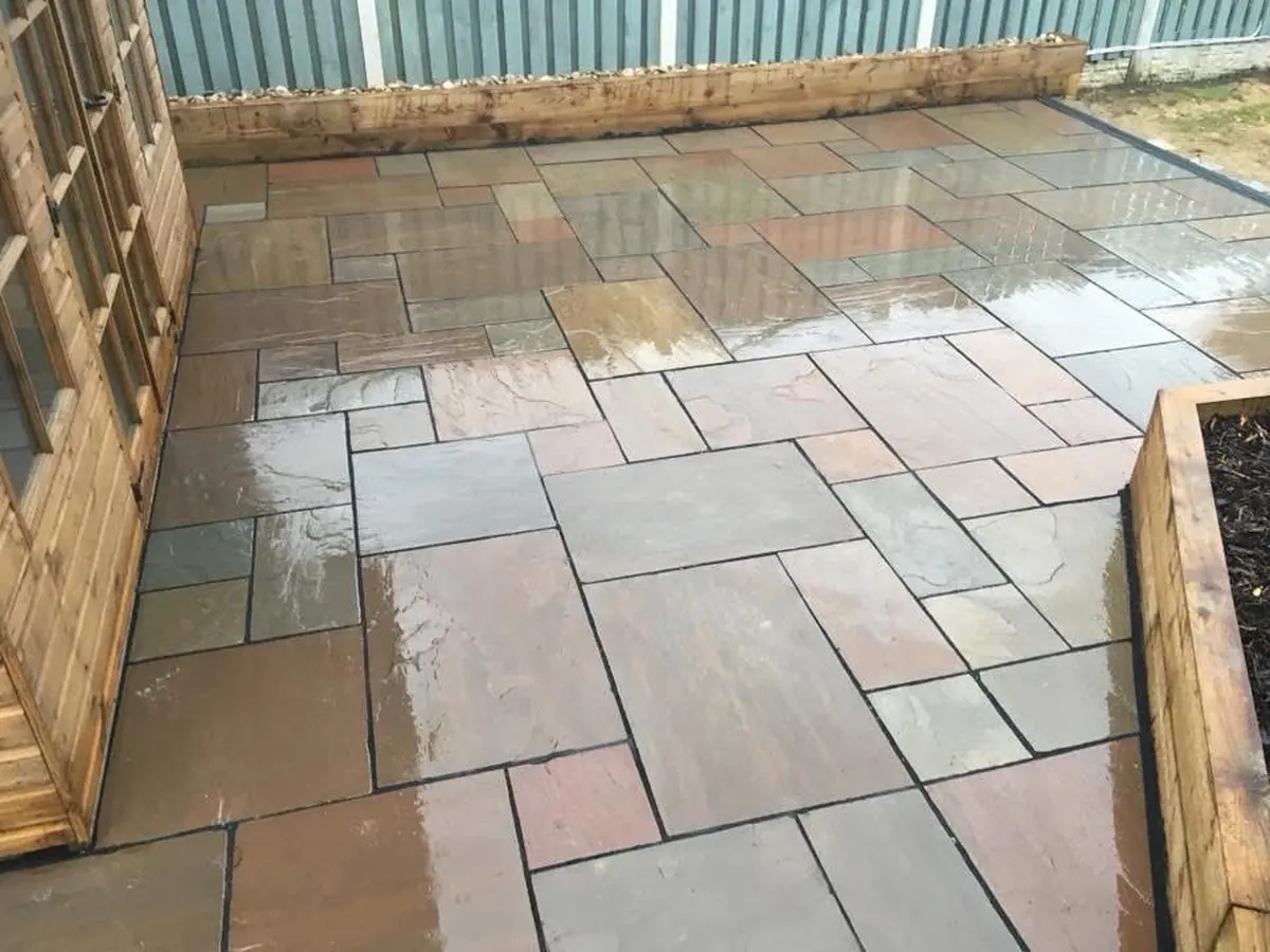 Indian sandstone patio finished with sleeper borders and gravel back-fill