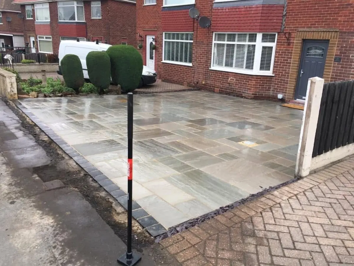Indian sandstone front driveway with charcoal block-paving border and kerb edging on a semi-detached home